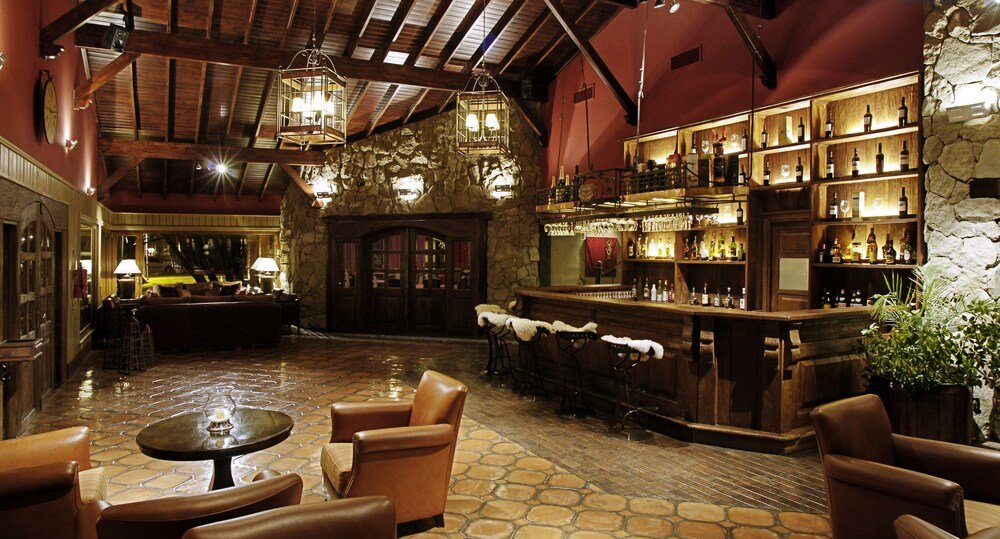 Sector de bar con muros de piedra y muebles de madera