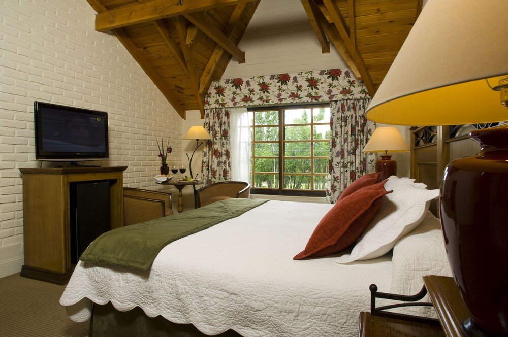Dormitorio con cama, televisor y ventana