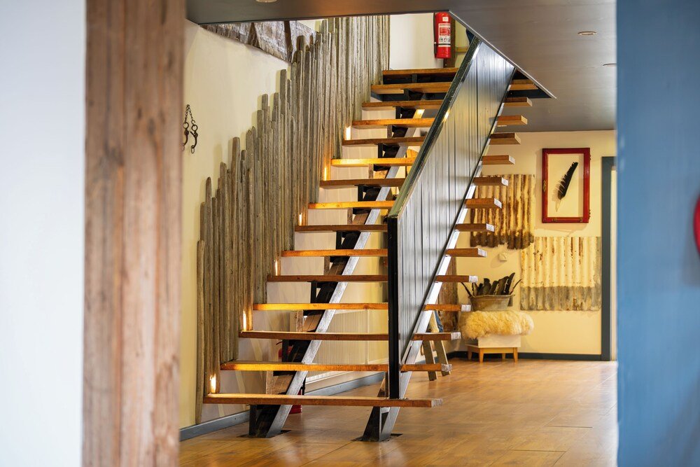Escalera moderna con escalones de madera y barandas metálicas