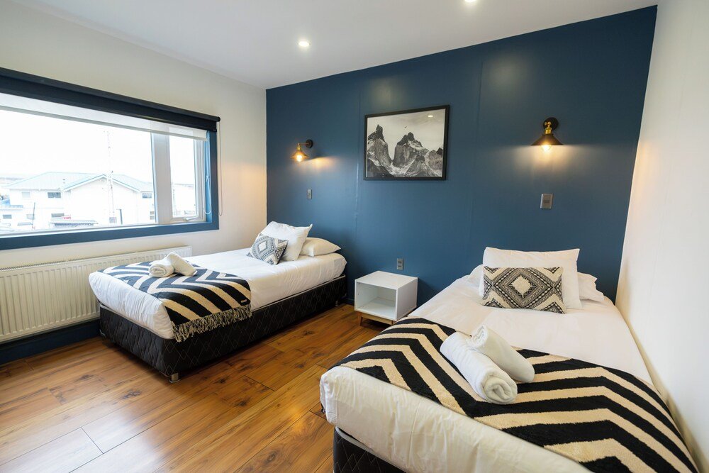Habitación de hotel con dos camas y un gran ventanal