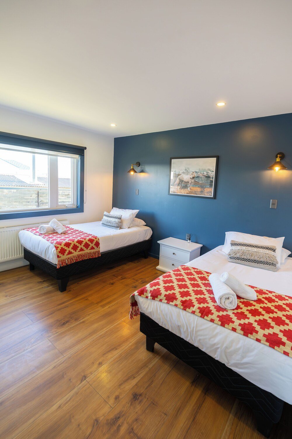 Habitación de hotel con dos camas y piso de madera