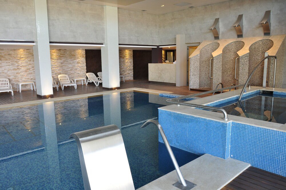 Modern indoor pool area with seating around it