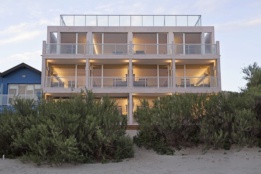 Edificio moderno de varios pisos con balcones y grandes ventanales