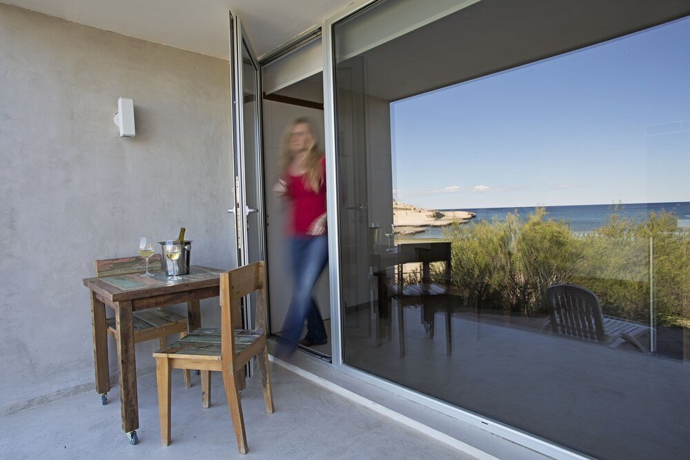 Balcón con mesa, sillas y vista al mar