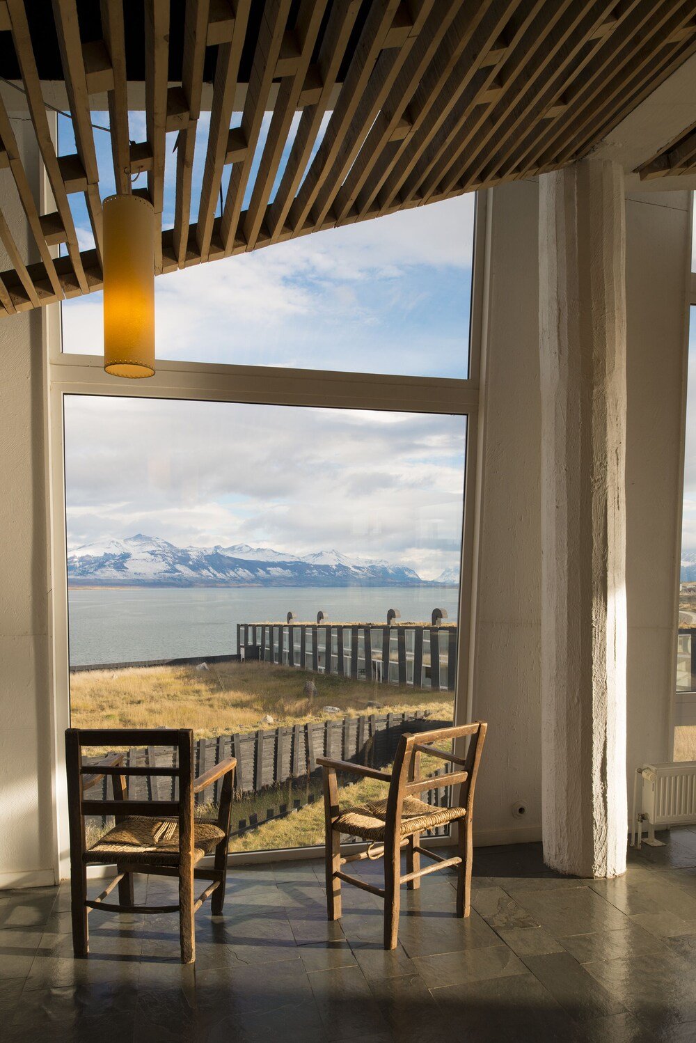 Habitación con grandes ventanales hacia el fiordo en Remota Hotel