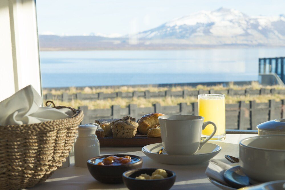 Mesa de desayuno con facturas y panes en Remota Hotel