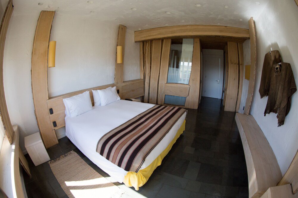 Habitación con cama grande y detalles de madera en Remota Hotel