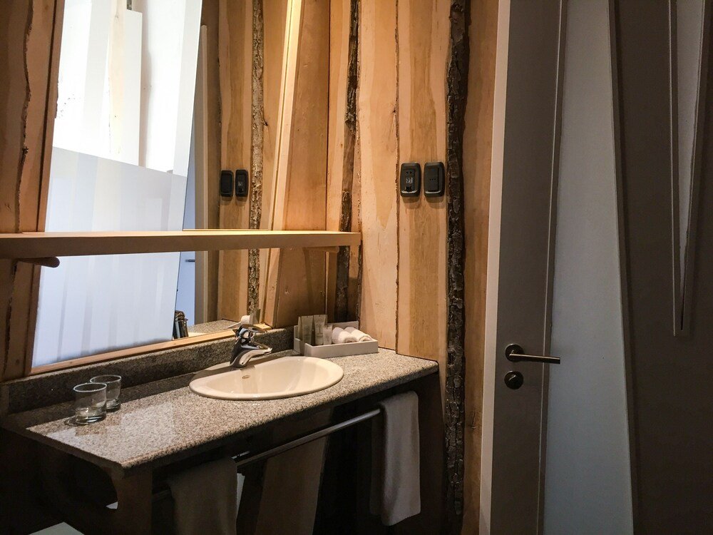Baño con una pared de madera en Remota Hotel