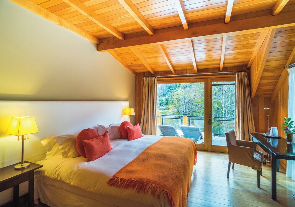 Dormitorio con cama y dos mesas de luz en tonos cálidos