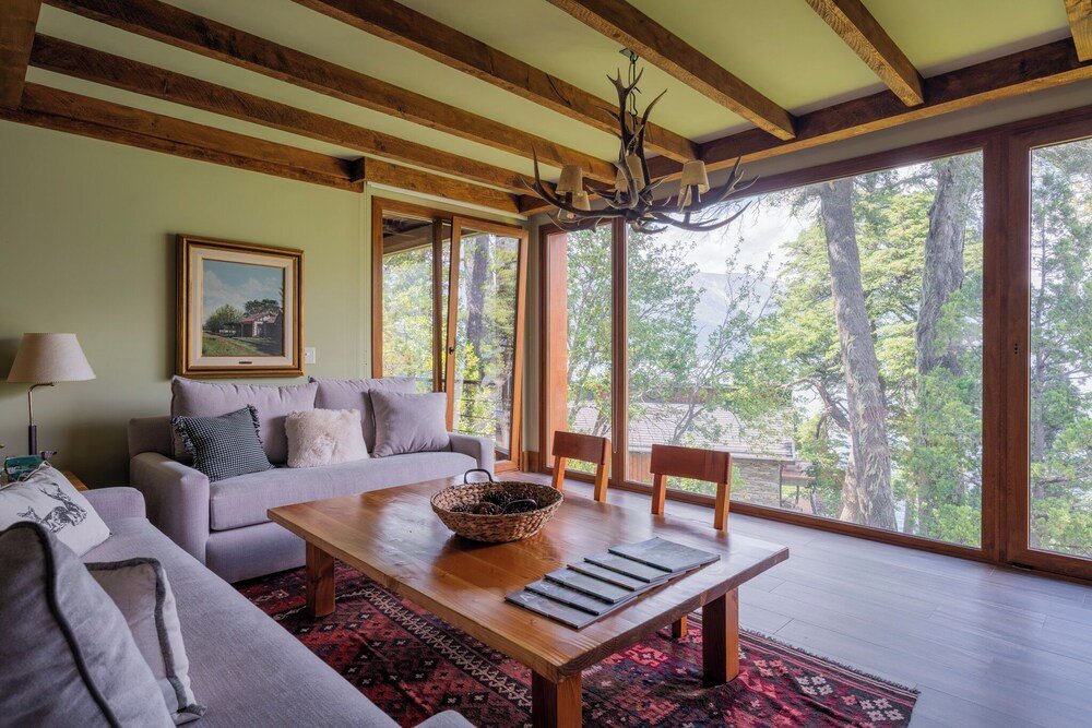 Amplio living con una gran mesa de madera, un sofá y vista