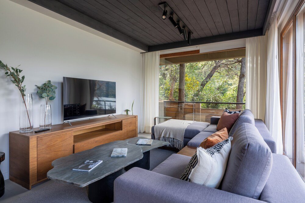 Living moderno con sofá gris y mueble de madera para el televisor