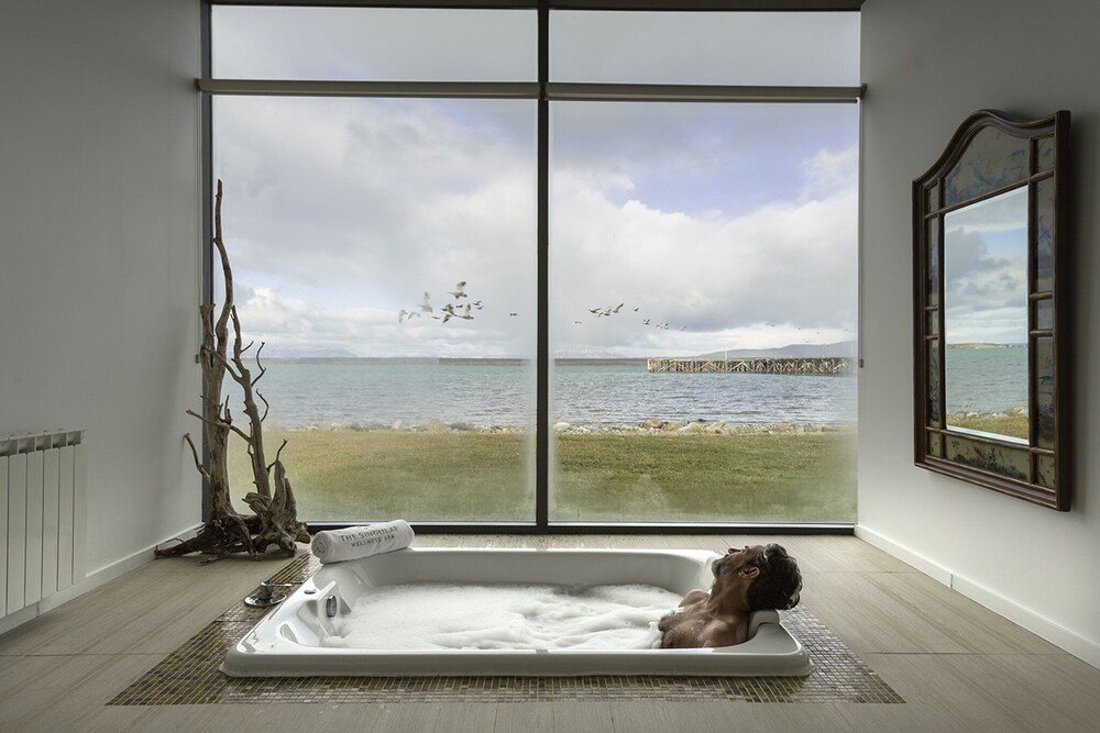 Room with a large window overlooking the water at The Singular Patagonia