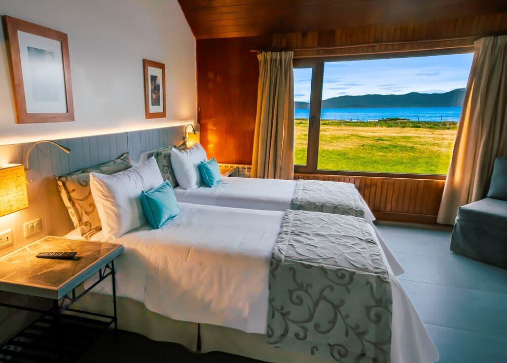 Habitación con dos camas, escritorio, lámpara y vista