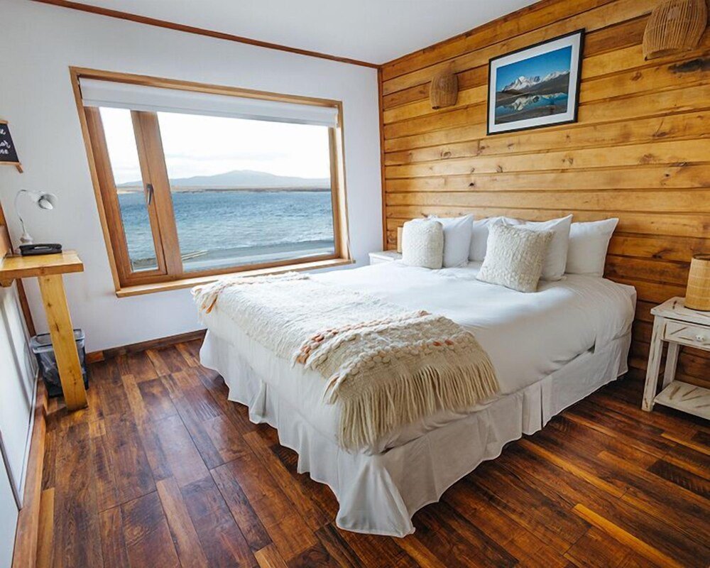 Bedroom with a large window and wooden walls