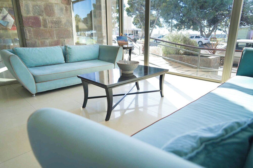 Living moderno con sofá celeste y mesa ratona de vidrio